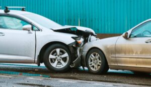 There's been a car collision on the street involving two vehicles crashing into each other from the front.